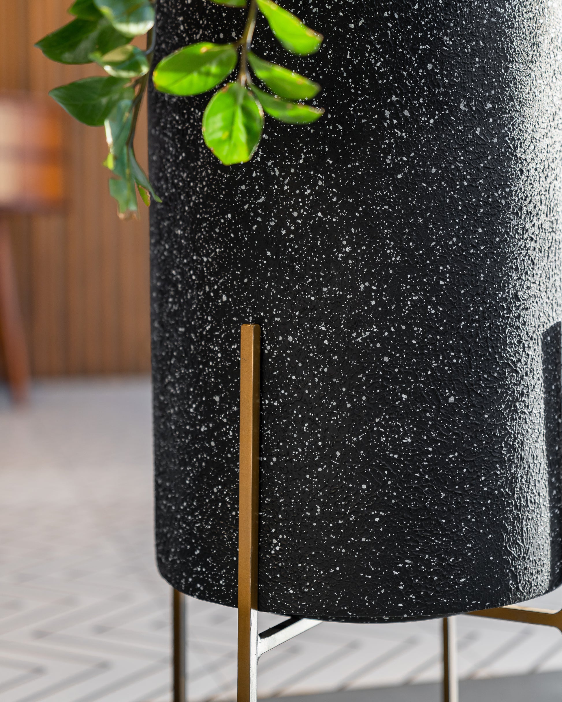 Buy Black Sleek Planter with metal stand for living room. Buy black colour flower pots for your home or office spaces. This modern planter works well indoors. This tall round planter can be kept in any home corner. Free shipping pan India.